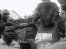 Lumumba (center), detained by Mobutu's soldiers, before transport to Thysville Lumumba arrested.jpg