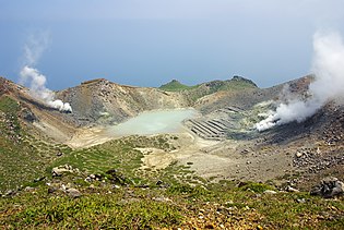 The crater on the highest peak (Otake) in Nakano-shima. The stripes that can be seen at the right in this photograph are disused sulfur mining facilities. Nakanoshima kakou.jpg