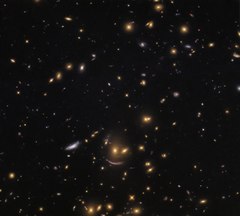 In SDSS J0952+3434, the lower arc-shaped galaxy has the characteristic shape of a galaxy that has been gravitationally lensed.[48]