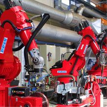 2 больших промышленных робота обрабатывают материал в сварочной камере