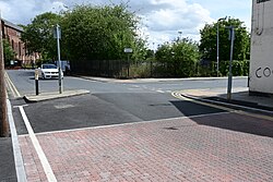 This image depicts the top terminus of the paving scheme at the junction with Estcourt Street.