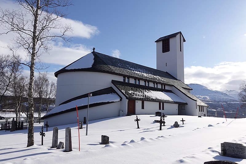 File:SALANGEN KIRKE Lutheran church 1981 Sjøvegan Troms Norway Kirkegård minnelund Cemetery Gravminner steiner støtter Snø sol Snow blue sky mai 2022-05-04 DSC05682.jpg