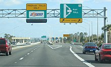 Collecting tolls on SR 417 near Orlando, Florida, United States. This shows the two common methods of collection of tolls: tollbooth (on right) and electronic toll collection (on left). SR 417 University Toll Plaza.jpg