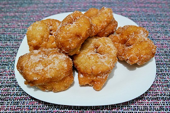 Sfenj sprinkled with sugar and served on a plate