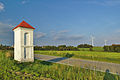 Výklenková kaplička v poli u silnice z Protivanova na Nivu, v pozadí dvě ze tří tamějších větrných elektráren