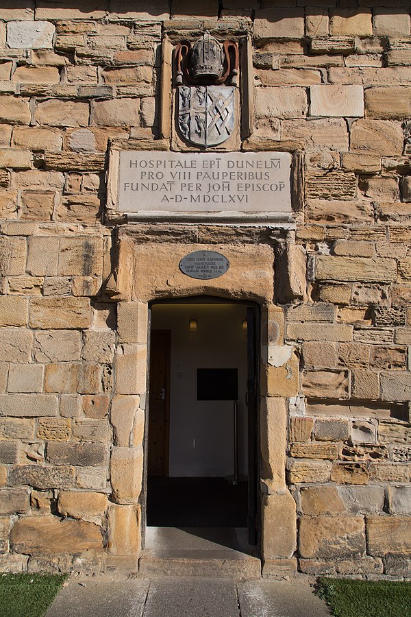 Entrance to almshouses for 8 paupers established in Durham in 1666 by John Cosin, Bishop of Durham. Arms: See of Durham impaling Cosin