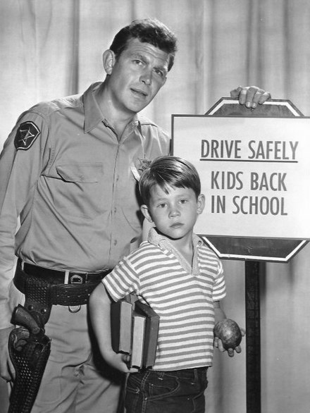 A publicity photo from The Andy Griffith Show showing Griffith and Howard in character as Andy and Opie Taylor (1961)
