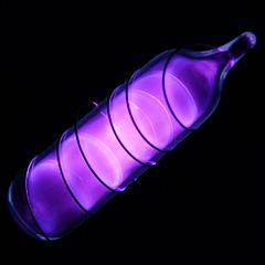 Glass tube shining purple light with a wire wound over it