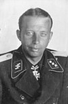 A man wearing a military uniform and a neck order in the shape of a cross.