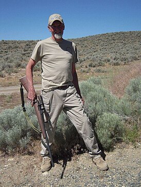 Чак Моуинни с репликой снайперской винтовки M40 (2013 год)