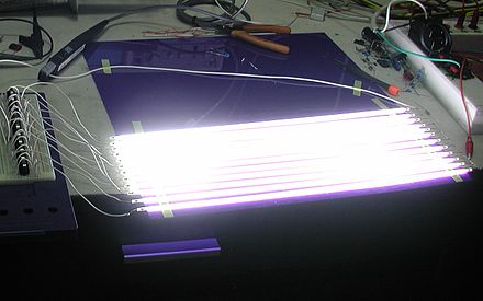 A cold-cathode fluorescent lamp from an emergency-exit sign. Operating at a much higher voltage than other fluorescents, the lamp produces a low-amperage glow discharge rather than an arc, similar to a neon light. Without direct connection to line voltage, current is limited by the transformer alone, negating the need for a ballast.