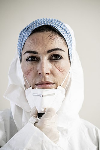 Talianska zdravotná sestra na konci pracovnej zmeny počas vrcholiacej pandémie ochorenia COVID-19 v marci 2020