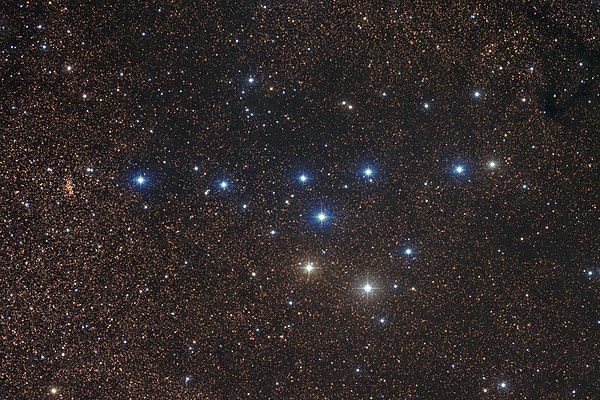 A picture of stars, with a group of appearingly bright blue and white stars. The bright stars together are identified as the asterism Coathanger resem