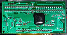 A chip-on-board (COB) covered with dark epoxy Famicom clone PCB.jpg