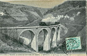 Die Jura Vicinal Railways Straßenbahn auf einem der Viadukte der Linie Lons - Saint-Claude, die in abgelegener Gegend gebaut wurde, mit dem Creux de Revigny im Hintergrund.