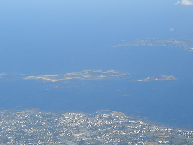 An aerial shot showing Jethou centre right next to its bigger neighbour Herm, with Sark in the background and the east coast of Guernsey.