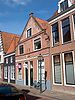 Huis onder een dak en achter een gevel met het buurnummer 85; pui later gedicht; gevelsteen