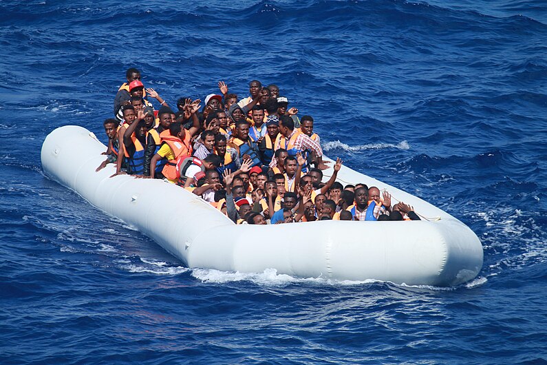 Inflatable boat carrying migrants approaching USS Carney (DDG-64) in the Mediterranean 160729-N-EU999-004.jpg