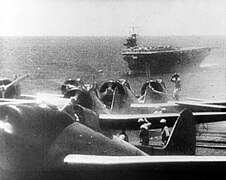 Bombarderos en picáu Aichi D3A1 Tipu 99 Val de la segunda folada preparar pa desapegar. Al fondu ve'l portaviones Sōryū.