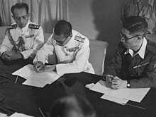 Japanese officials signing the surrender of Penang documents on board HMS Nelson on 2 September 1945. Japanese surrender Penang.jpg