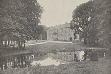 Photographie ancienne avec un château se reflétant dans un étang, au milieu d'arbres majestueux