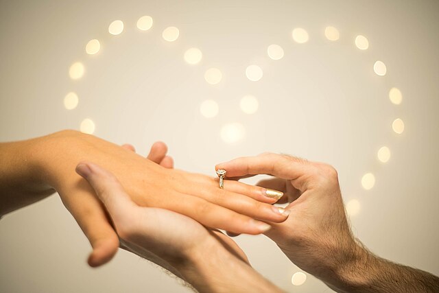 640px Man putting engagement ring on woman%27s finger