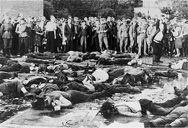 Civilians and German soldiers looking at the massacre of 68 Jews in the Lietukis garage of Kaunas on June 25 or 27, 1941, during the Kaunas pogrom