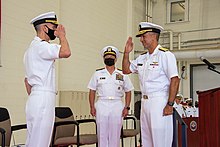 After reading his orders from the podium, Vice Admiral Carl Chebi, right, salutes Vice Admiral G. Dean Peters and assumes duties as Commander, Naval Air Systems Command on September 9, 2021, at Naval Air Station Patuxent River, Maryland. NAVAIR Change of Command 2021 210909-N-HL559-1001.jpg