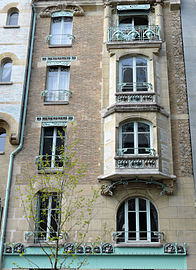 Photo en couleur d'une partie de façade avec à droite des bow-windows les uns au-dessus des autres