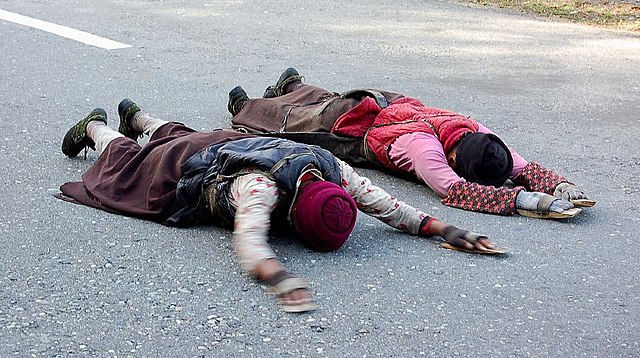 Tibetans on a pilgrimage to Lhasa, doing full-body prostrations, often for the entire length of the journey