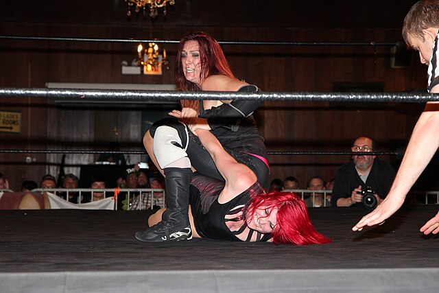 Eagles placing Sweet Saraya in a submission hold during a SHIMMER match in 2015
