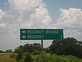 Sign on Texas State Highway 45 directing motorists to isolated Regency Suspension Bridge in Texas Hill Country