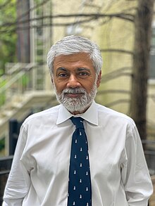 Photo of Tunku Varadarajan, dressed in white shirt, blue tie.