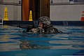 U.S. Army Sgt. 1st Class Frank Minnie, the noncommissioned officer in charge for the 4th Public Affairs Detachment, traverses a pool on his rucksack during water survival training at Fort Hood, Texas, Aug. 24 110824-A-MG489-005.jpg