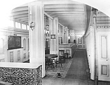 Forward passenger accommodation on Wide West. Note window labeled "office", probably that either of the purser or the freight clerk. Jacketed steam drum also shown, enclosed with a low rail. Wide West steamboat interior 02.jpeg