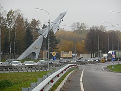 Памятник «Слава советским покорителям неба» Самолёт истребитель-бомбардировщик Су-7Б, на дальнем плане въезд «А» Чкаловского аэродрома