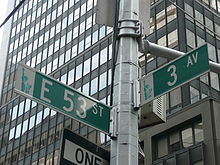 Фотография смотрит вверх на перекрестке улиц полюс, где 53-я Восточная улица и Третья авеню.