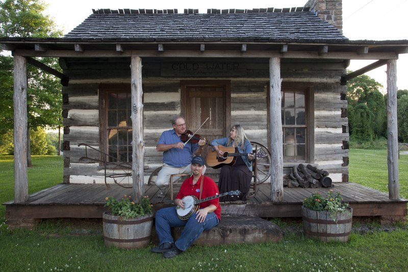 File:Banjo player Kevin Harris with the Huntley Sisters Blue Grass Group, Larry McWilliams on the fiddle and Nancy Muse on the guitar pose at the one-room log cabin that once served as a stagecoach stop in LCCN2010640711.tif