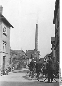 Straßenszene in Stuttgart 1929, an einem Schornstein eine Werbeaufschrift der KPD für den 1. Mai