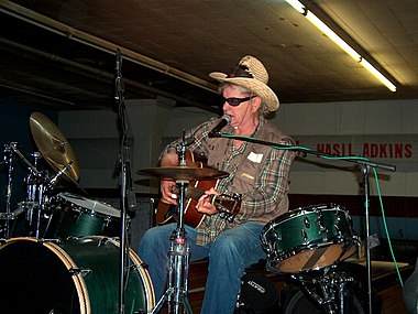 Adkins jouant de la guitare et de la batterie lors d'une performance en 2003 à Seidel Lanes à Baltimore