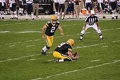 Mason Crosby kicks a field goal, held by Jon Ryan
