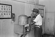 Un afro-américain en train de boire à une fontaine réservée aux "gens de couleur". 1939