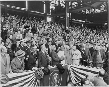 Een breed schot met de Amerikaanse president Harry Truman in het midden terwijl hij een honkbal gooit.