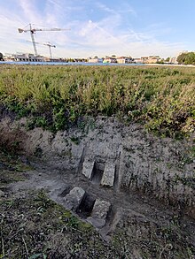 Une section de la rigole de Rungis (gallo-romaine) dans la plaine de Montjean avec l'agroquartier de Montjean en construction en arrière-plan.