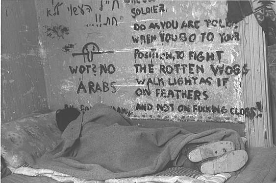 Israeli soldier sleeping during the 1947–1949 Palestine war, Kilroy is seen on the wall together with inscription "Wot? No Arabs", 1948