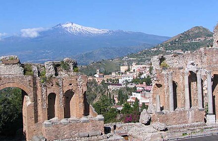 Ruins of the Greek theatre with the town and Mount Etna in the background