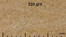 Makro fotoattēls ar 320 graudu smilšpapīru