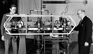 photograph of Essen and Parry standing beside the world's first atomic clock