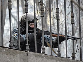 Poliziotto della Berkut punta il fucile sui manifestanti di Euromaidan