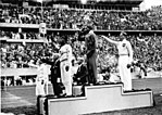 אוונס מצדיע לדגל ארצות הברית לאחר שזכה במדליית הזהב באולימפיאדת ברלין ב-1936. מאחוריו לוץ לונג הגרמני, זוכה מדליית הכסף, המצדיע במועל יד.